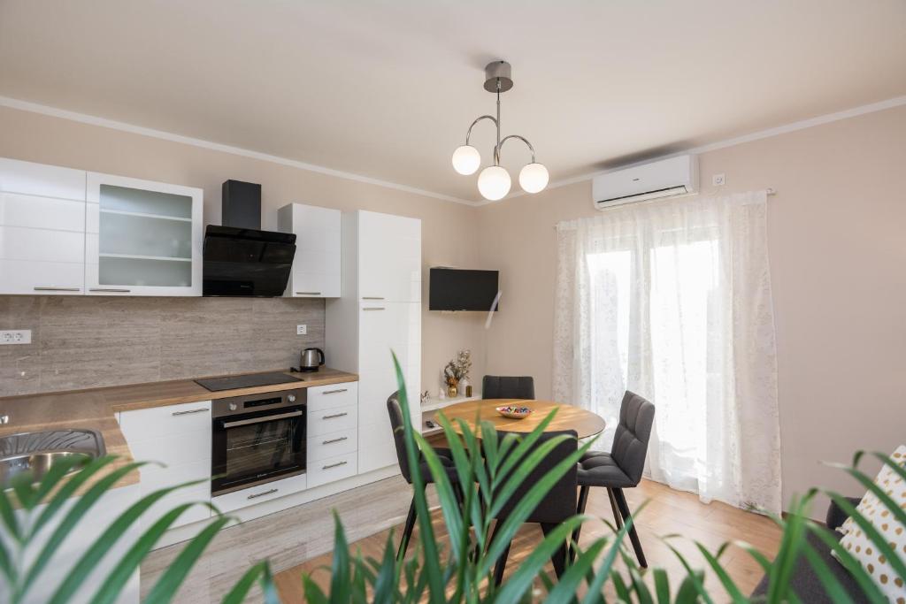 una cucina e una sala da pranzo con tavolo e sedie di Apartments Star a Zara (Zadar)