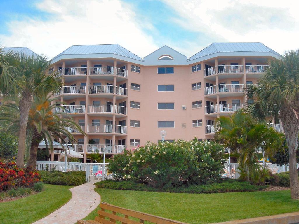 un gran edificio con palmeras delante en Sunrise Resort by Liberte', en St Pete Beach