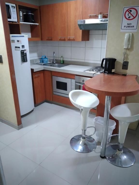 a kitchen with a small table and a white refrigerator at Apartment 209 in Santiago