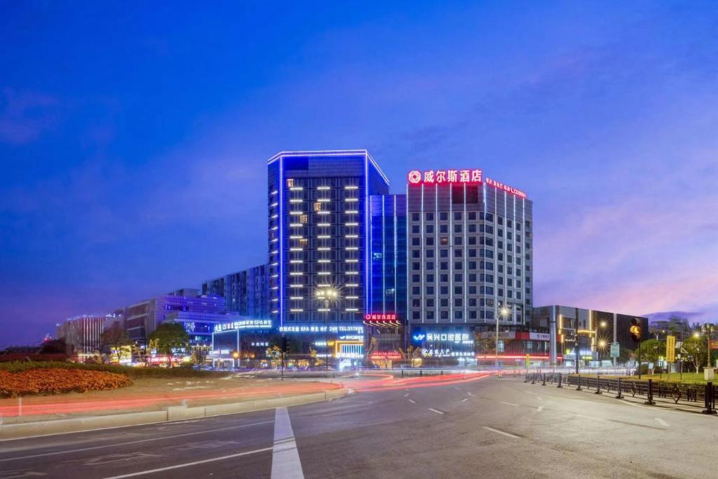 a large building with blue lights on it at night at Huzhou Wealth Hotel in Huzhou