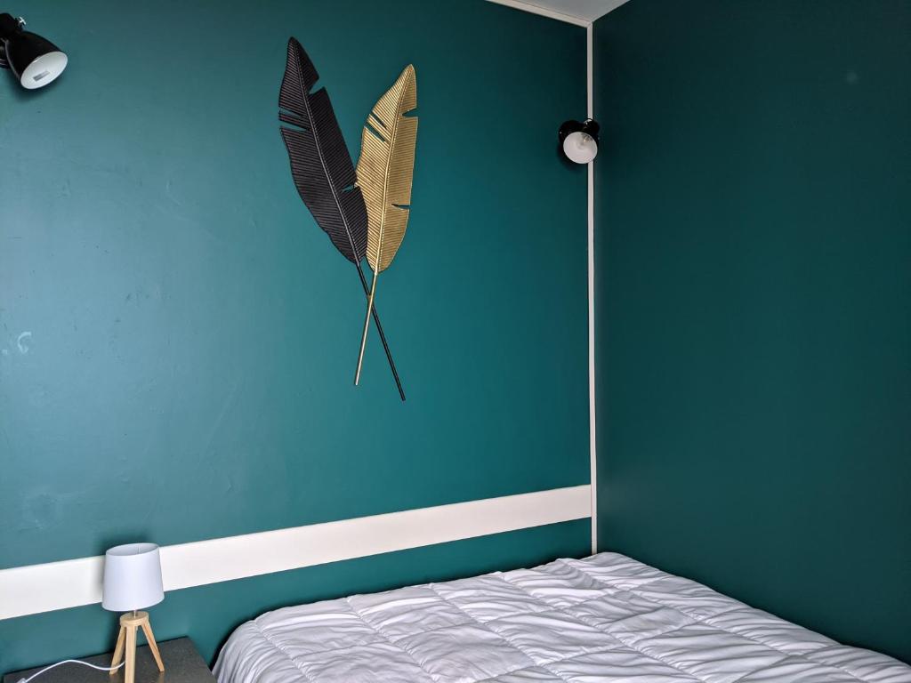 a bedroom with a blue wall with a butterfly kite on the wall at Saint-Etienne Appart&#39;hôtel de Bellevue in Saint-Étienne