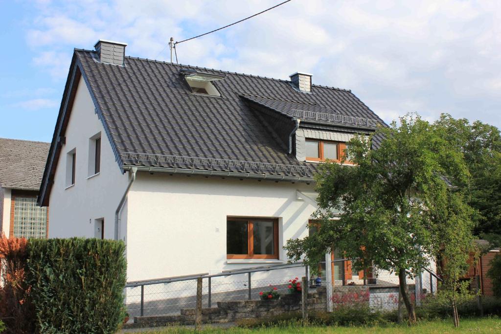 una casa bianca con tetto nero di Das Zweiradparadies a Mastershausen
