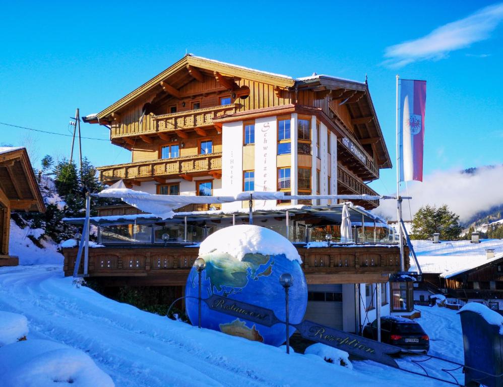 budynek w śniegu z nartami przed nim w obiekcie Hotel Schweizerhof w mieście Oberau