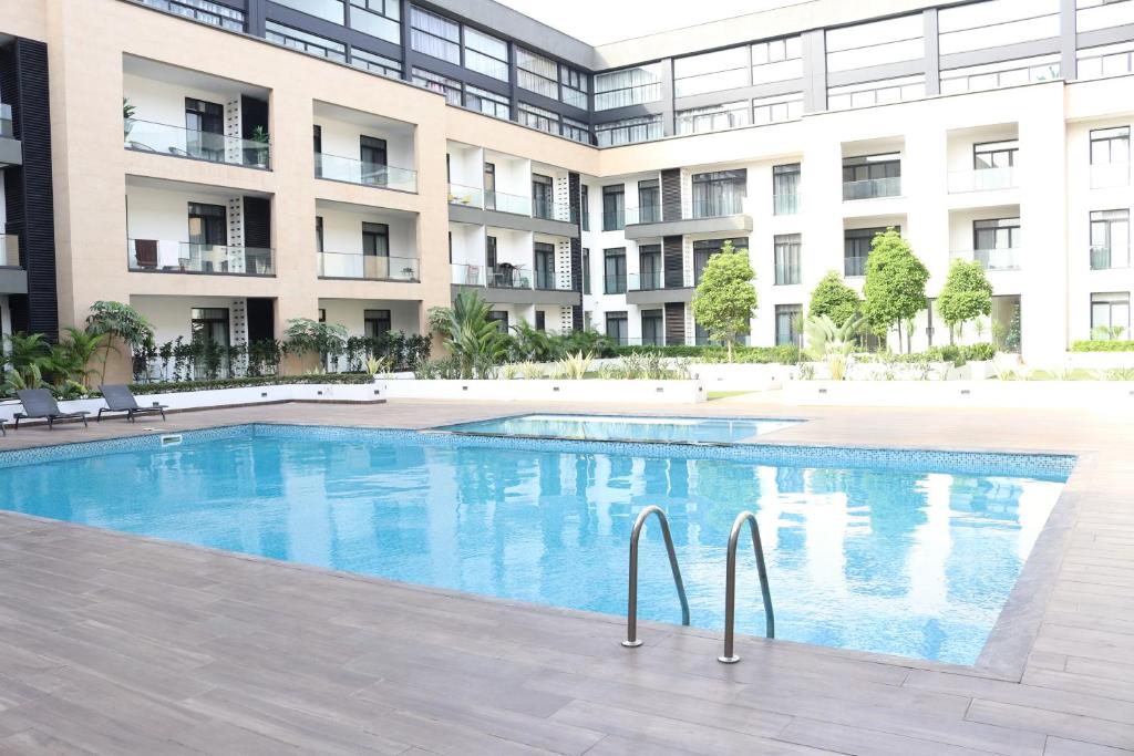 a swimming pool in front of a building at APARTMENTS GH - Accra - Cantonments - Embassy Gardens in Accra