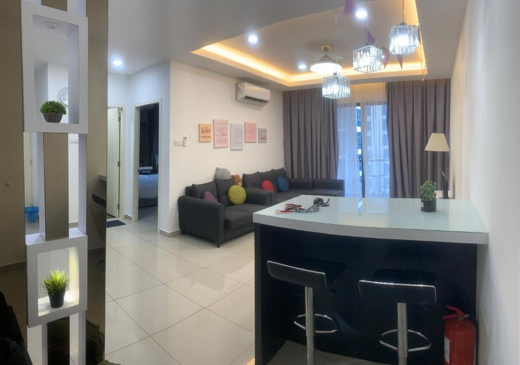 eine Küche und ein Wohnzimmer mit einem Sofa und einer Bar in der Unterkunft Atlantis Residence#3409#1Bedroom#2-4Pax# in Malakka