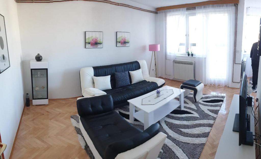 ein Wohnzimmer mit einem Sofa und einem Tisch in der Unterkunft Apartman Hana in Sanski most