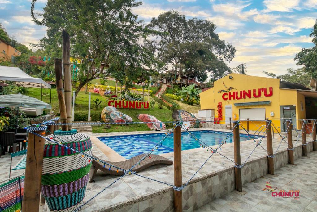 une piscine dans un parc d'attractions avec toboggan dans l'établissement MINCA Chunuu - glamping - coworking MINCA, à Minca