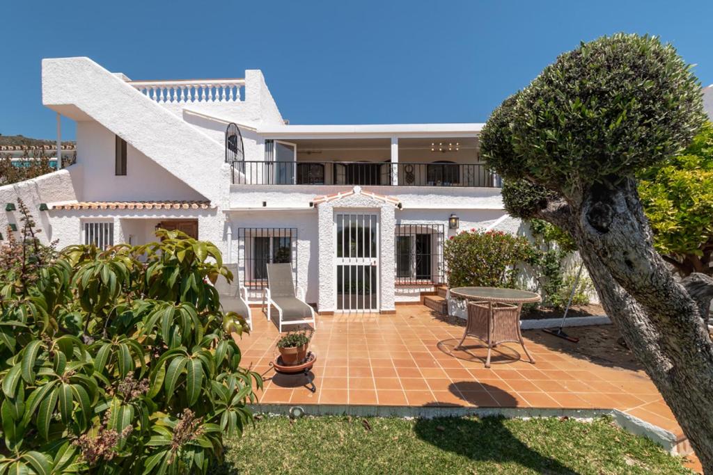 a white house with a patio and a tree at Villa Nerja Views Mediterranean Panorama in Nerja