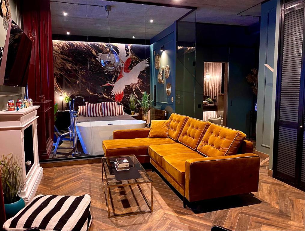 a living room with a yellow couch and a tub at Apartamenty Zamkowe Centrum in Kwidzyn