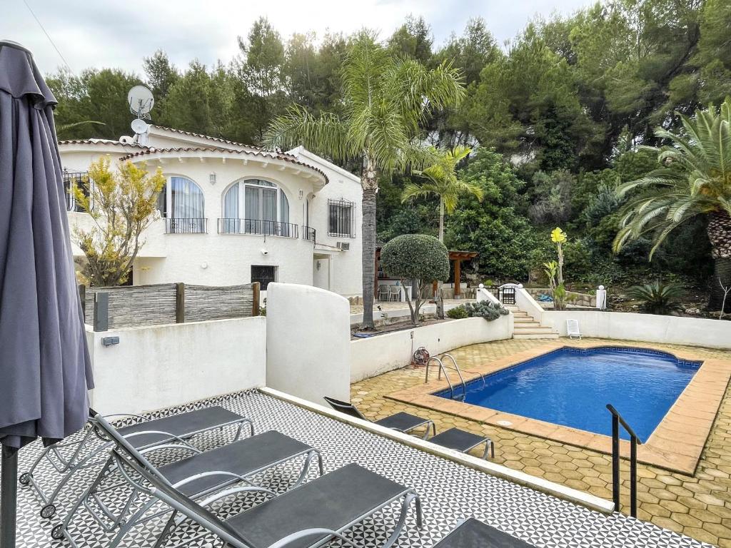 Villa con piscina frente a una casa en El Grande, en Benitachell