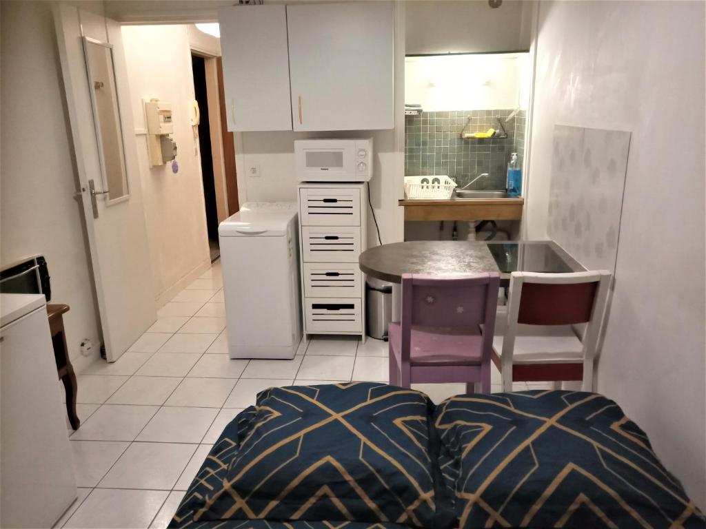 a small kitchen with a table and a small kitchen with a counter at APPARTEMENT PROCHE GARE ET CENTRE VILLE in Melun