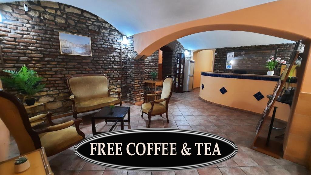 un salón de té y café gratuito con una pared de piedra en Pension City Center & L`Opera, en Praga