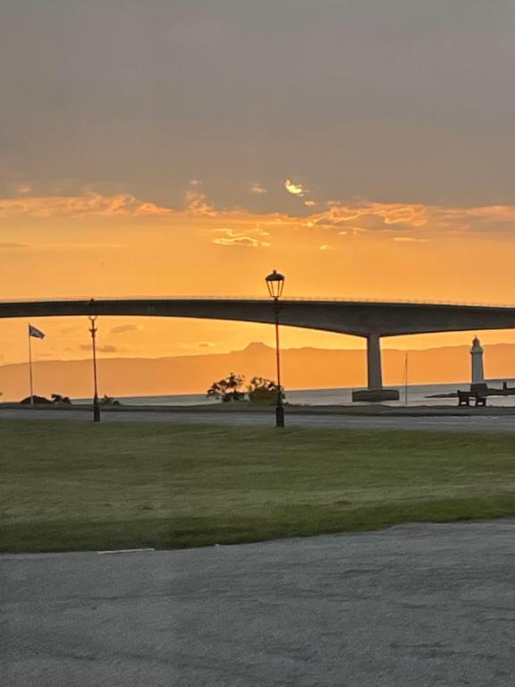 a view of a bridge at sunset with a lighthouse at Saucy Mary's Hostel in Kyleakin