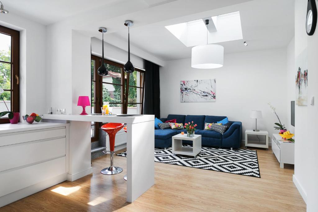 una cucina e un soggiorno con divano blu di Costa Apartments a Sopot