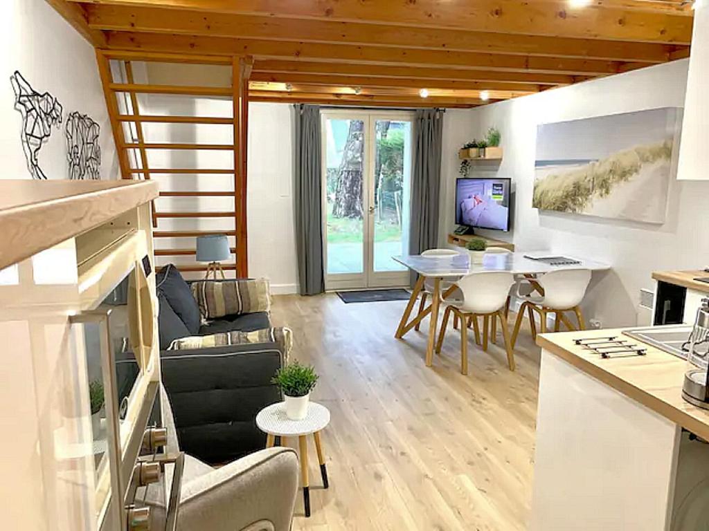 een woonkamer met een bank en een tafel bij Cottage T3 à 5 minutes à pied de la plage in Le Pouliguen
