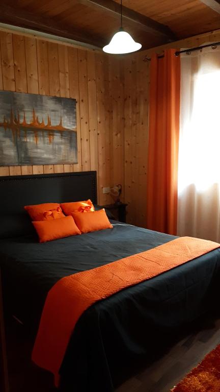1 dormitorio con 1 cama con almohadas de color naranja y ventana en Lety's House, en Civita Castellana