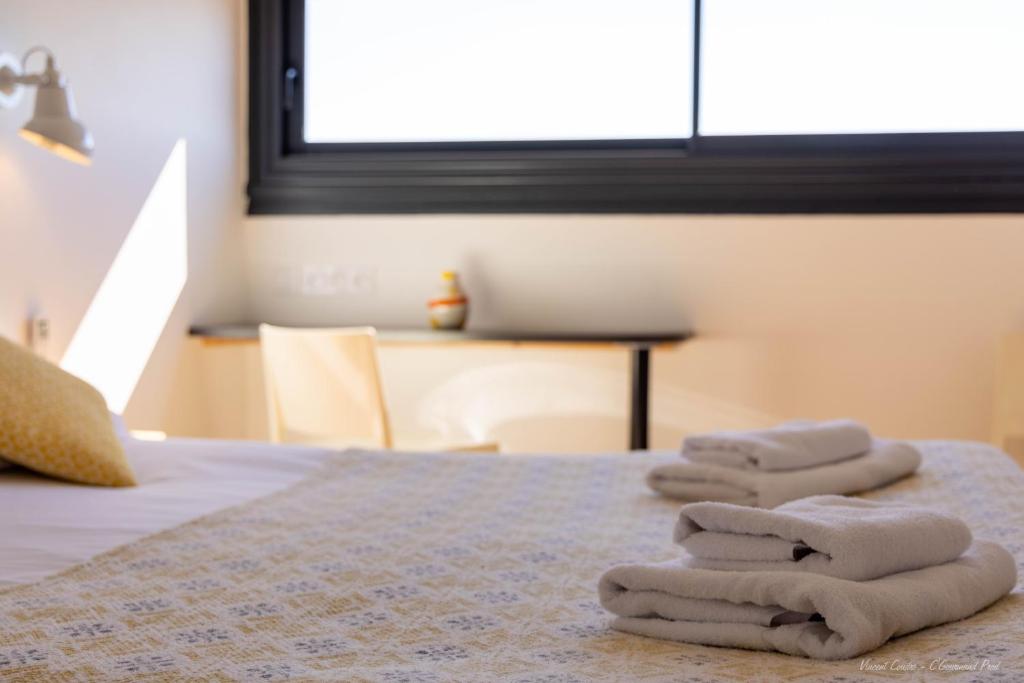Una cama o camas en una habitación de Logis Hôtels - Le Bellaroc - Hôtel 2 étoiles et Restaurant
