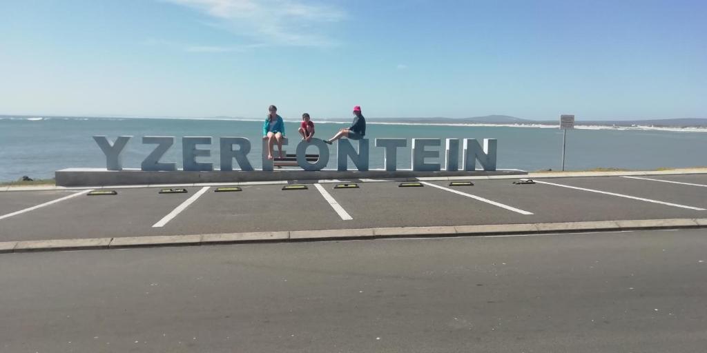três pessoas a andar numa placa perto do oceano em Intimi2 em Yzerfontein