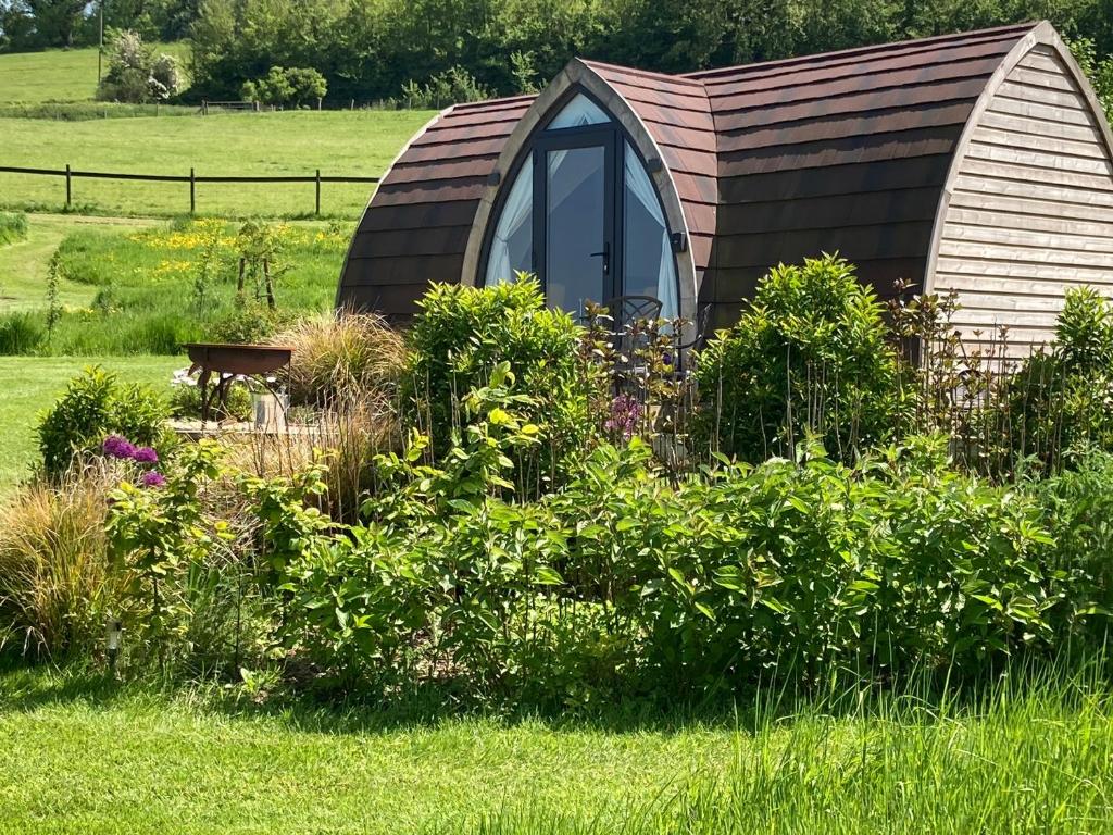 a small dome house in the middle of a garden at Slades farm Glamping in Westbury