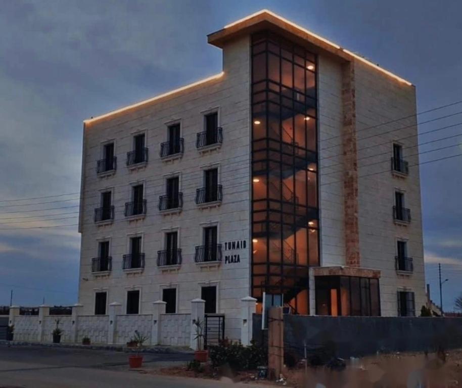 a large white building with a lot of windows at Tunaib Plaza in Aţ Ţunayb