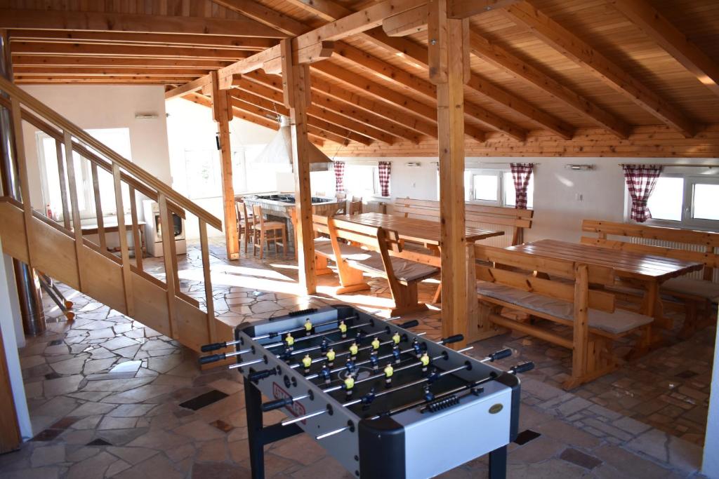 ein Zimmer mit einer Tischtennisplatte und Bänken in der Unterkunft Apartmani Vila in Kupres