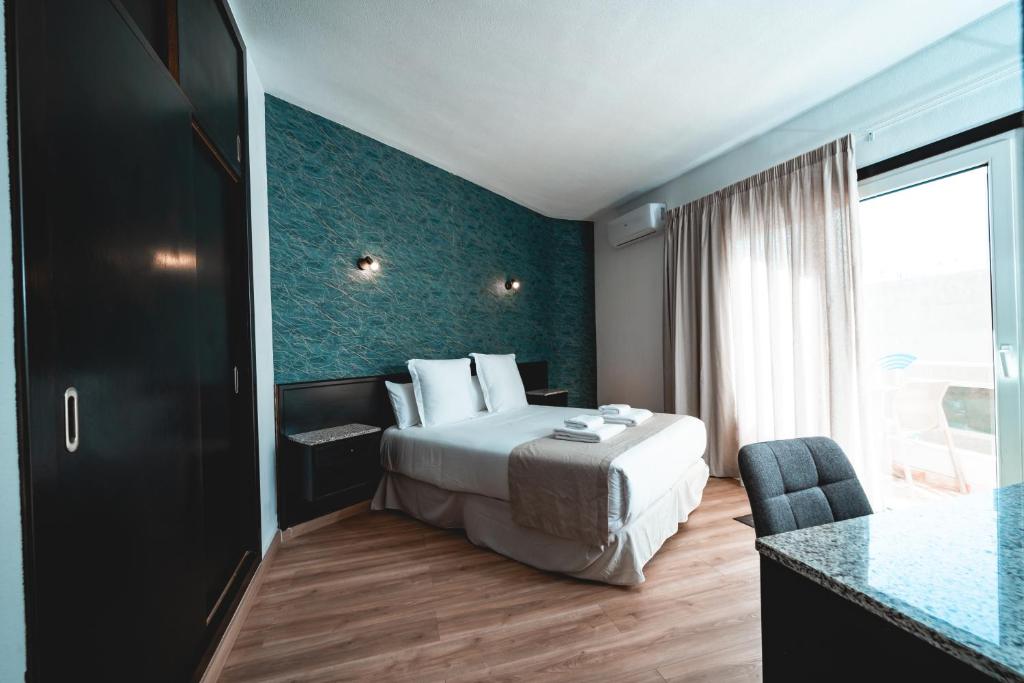 een hotelkamer met een bed en een groot raam bij Hotel Ventus in El Médano