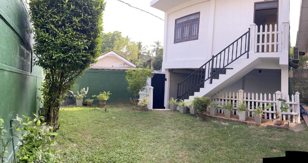 une cour en face d'une maison avec un escalier dans l'établissement Atrium Cottage, à Seeduwa