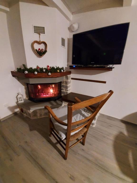 un salon avec une cheminée et une télévision dans l'établissement Il borghetto, à Fanano