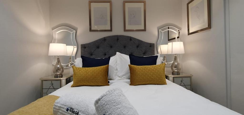 Ellipse Luxury High Rise Apartment في ميدراند: غرفة نوم بسرير ابيض كبير ومصباحين