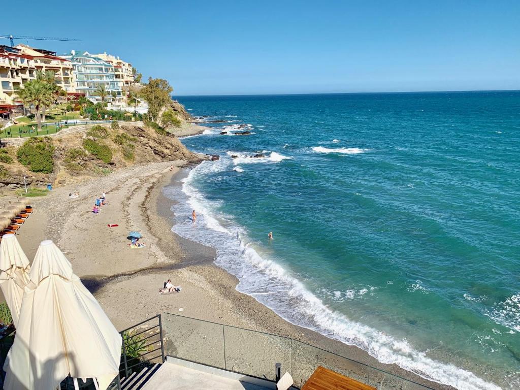 plaża z ludźmi leżącymi na piasku i oceanie w obiekcie Spectacular Apartment With Amazing Sea Views! w mieście Benalmádena