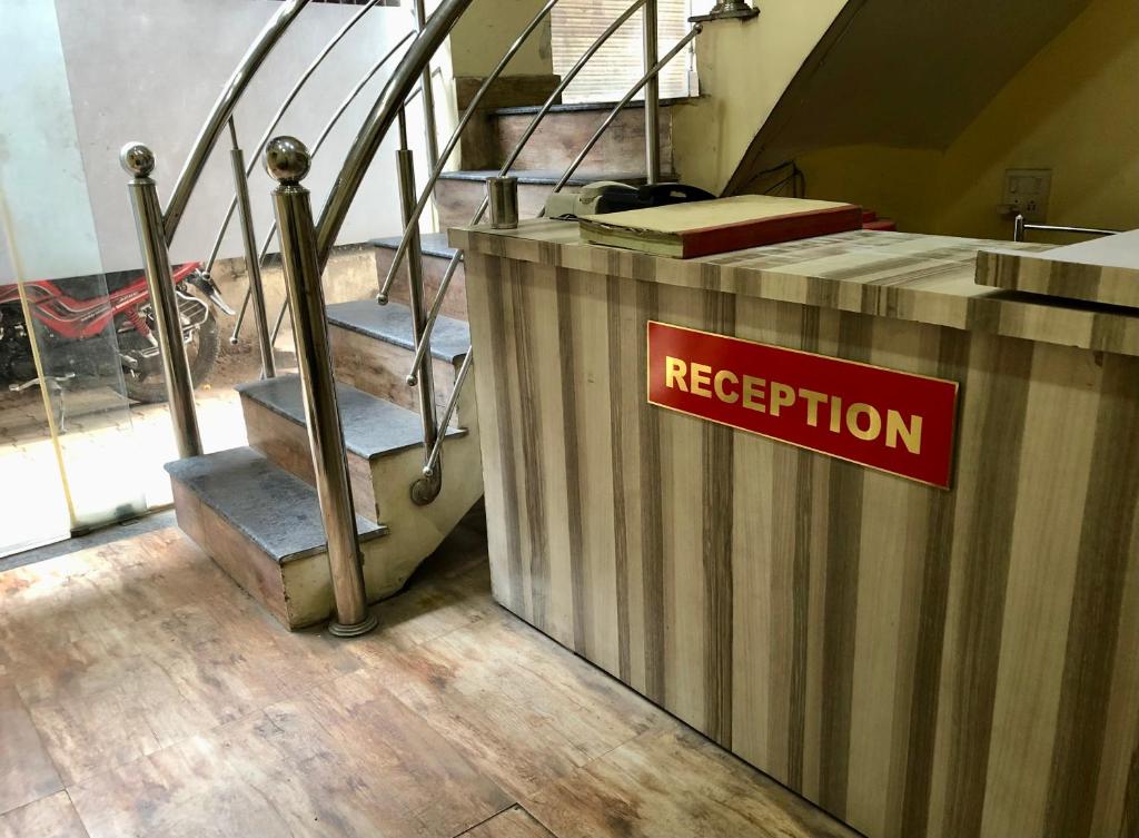 a red sign on a counter next to some stairs at Hotel Abhishek in Jhānsi