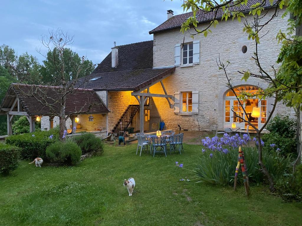 a house with a table and chairs in the yard at Le prieuré de Sainte Vertu in Sainte-Vertu