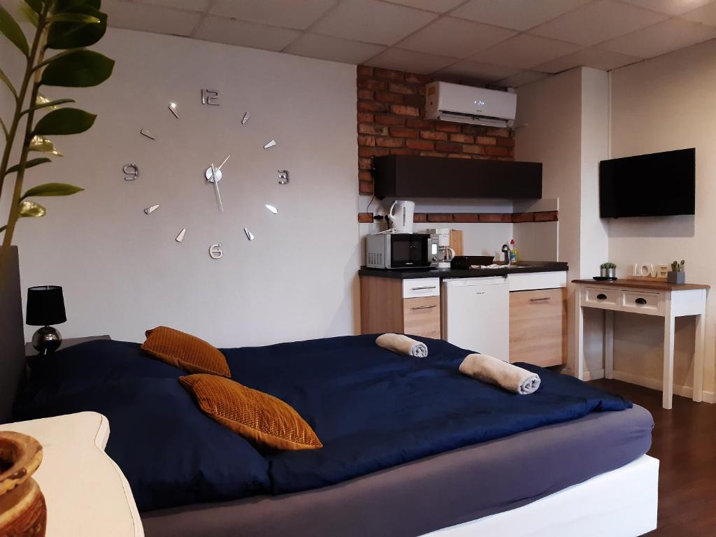 een slaapkamer met een grote klok aan de muur bij Ady Apartman in Tata