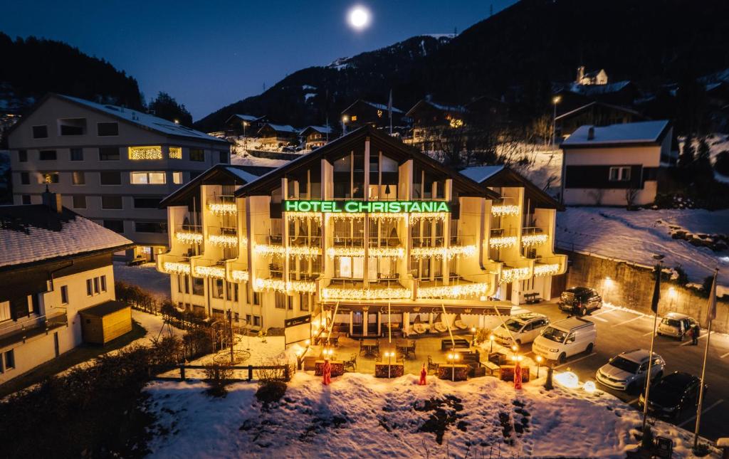 ein Hotel im Schnee in der Nacht in der Unterkunft DESIGn und FERIEN HOTEL CHRISTANIA in Fiesch