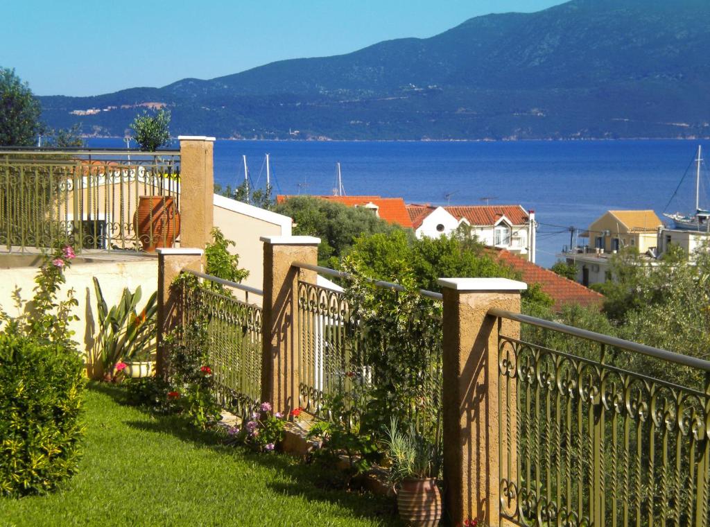 a balcony with a fence and a view of the water at GARDEN VILLAS in Ayia Evfimia