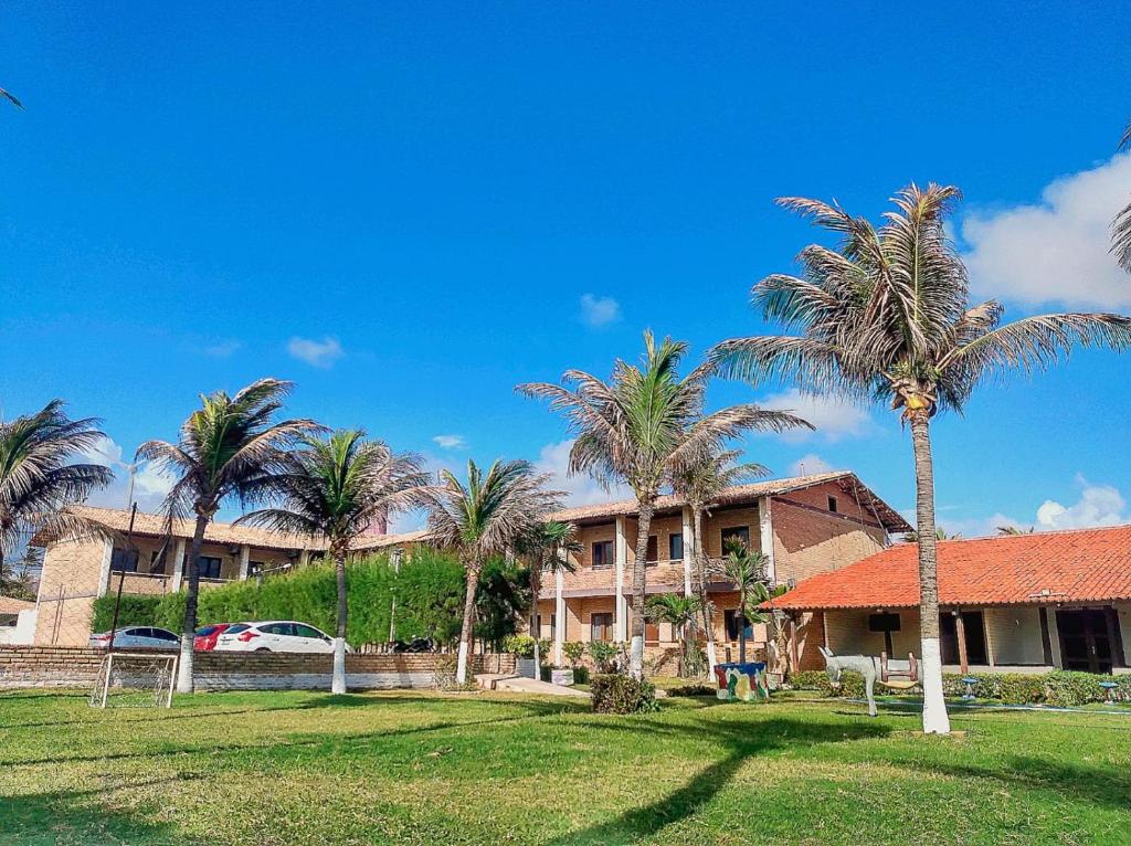 um edifício com palmeiras em frente em HOTEL DAS FALESIAS em Beberibe