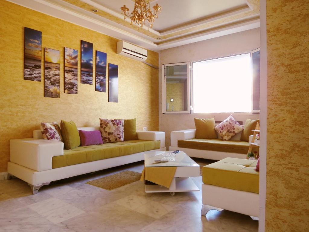 a living room with two couches and a table at Beautiful appartment with a glorious sea view in Monastir