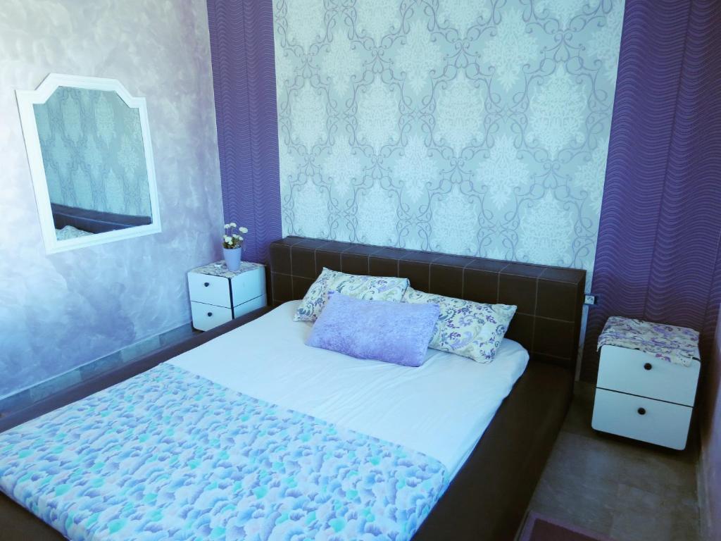 a bedroom with a bed with a mirror and purple walls at Beautiful appartment with a glorious sea view in Monastir