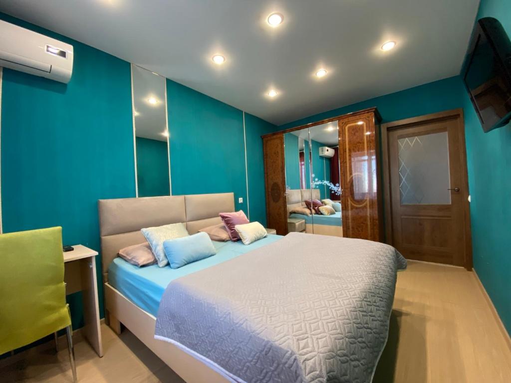 チェリャビンスクにあるInnHome Apartments Lenina Avenue 38のベッドルーム1室(青い壁のベッド1台、鏡付)