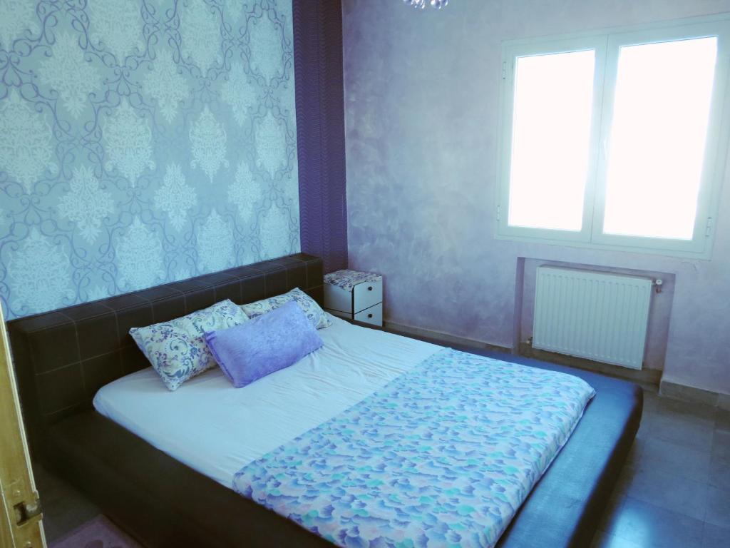 a bedroom with a bed with two pillows on it at Beautiful appartment with a glorious sea view in Monastir