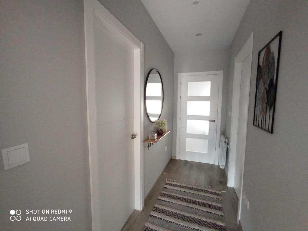 um corredor com uma porta branca e um espelho em Apartamento Ría de Vigo em Pontevedra