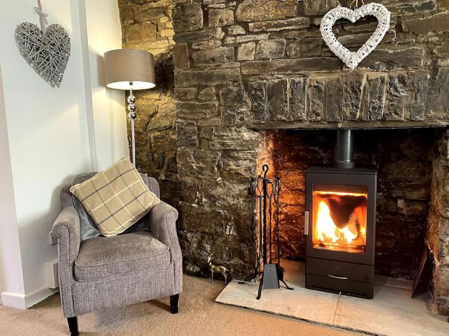 a living room with a chair and a fireplace at The Cwtch, Log Fire, Sleeps 5, Nr Zip World, Brecon and Bike Park Wales in Aberdare