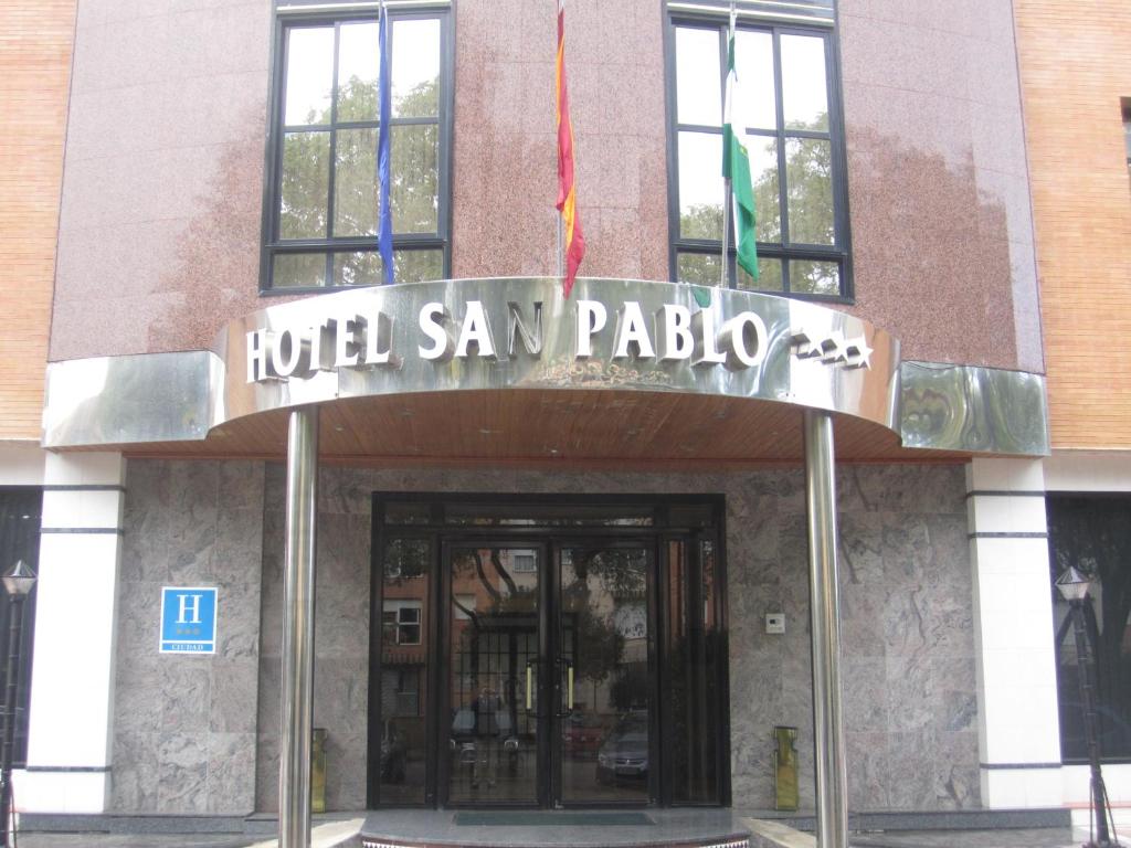 a building with a sign on the front of it at Hotel San Pablo Sevilla in Seville