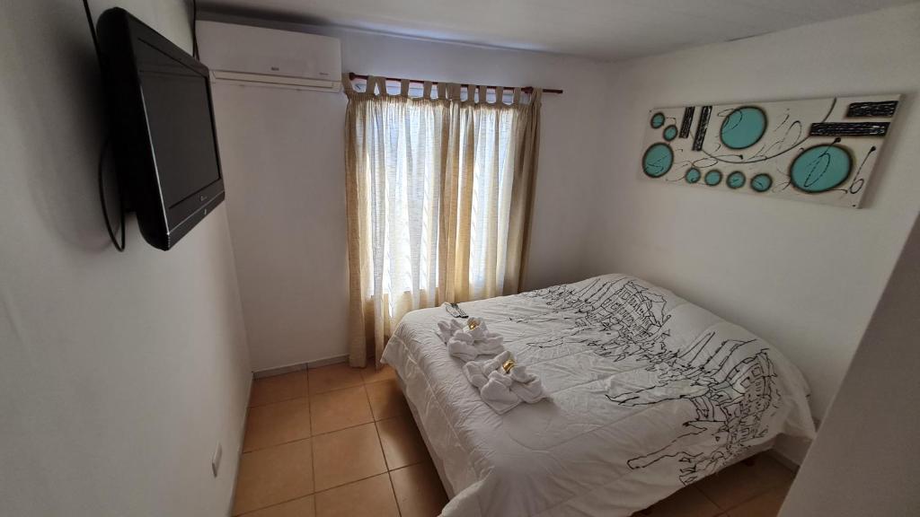 a bedroom with a bed and a flat screen tv at Vicky House in La Falda