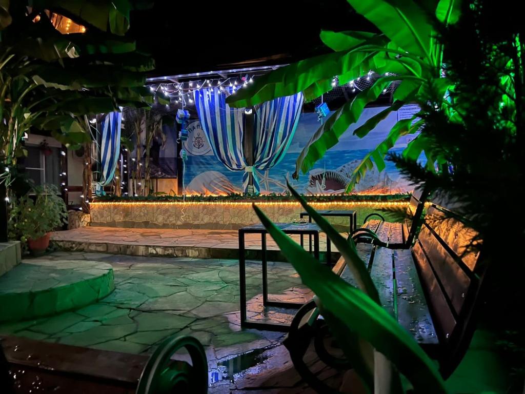 a patio with two benches and a stage with blue lights at U Palycha Guest House in Sukhum