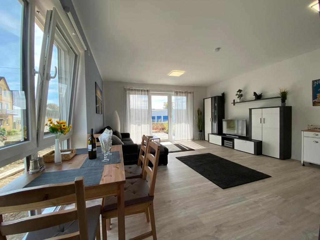 sala de estar con mesa de comedor y sala de estar con sofá en Haus am Brunnen Wohnung 2, en Klosterkumbd