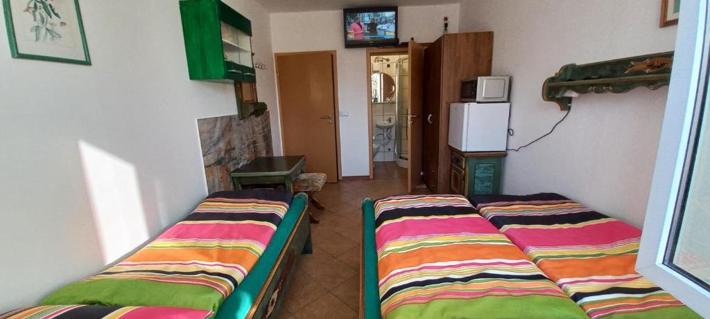 a room with two beds in a room with a refrigerator at Pokoje goscinne DW Antom in Dźwirzyno