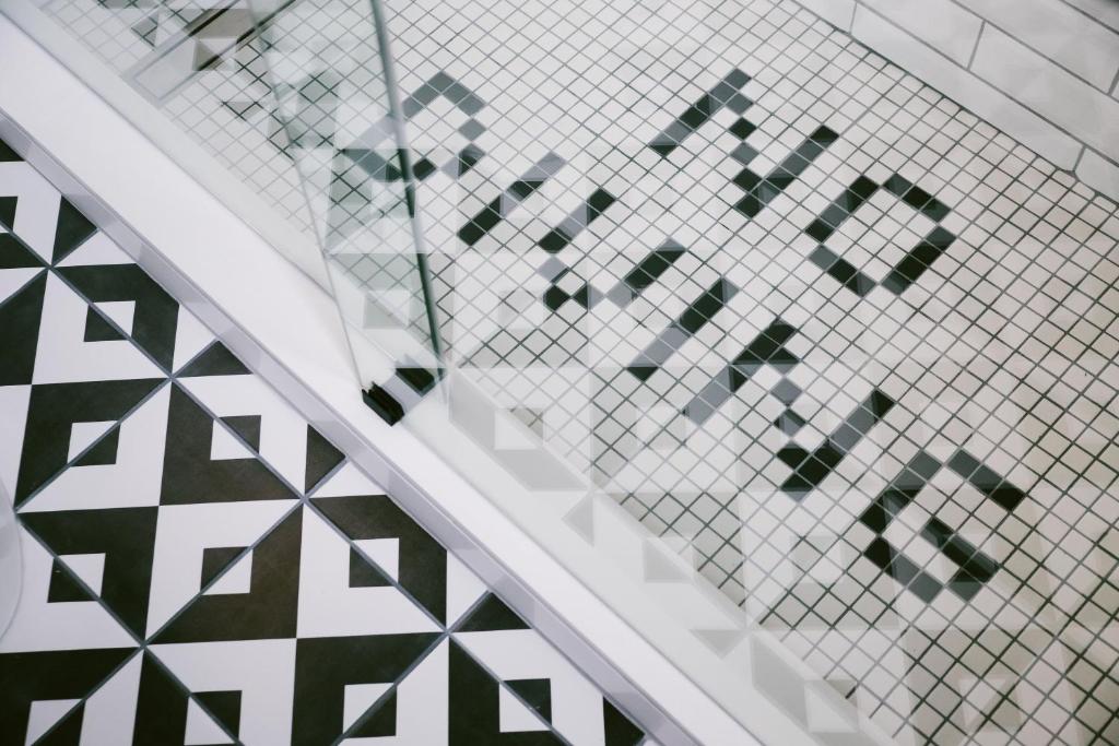 a stairwell with a patterned tile wall and a stair case at Hotel Belmont Vancouver - MGallery Collection in Vancouver