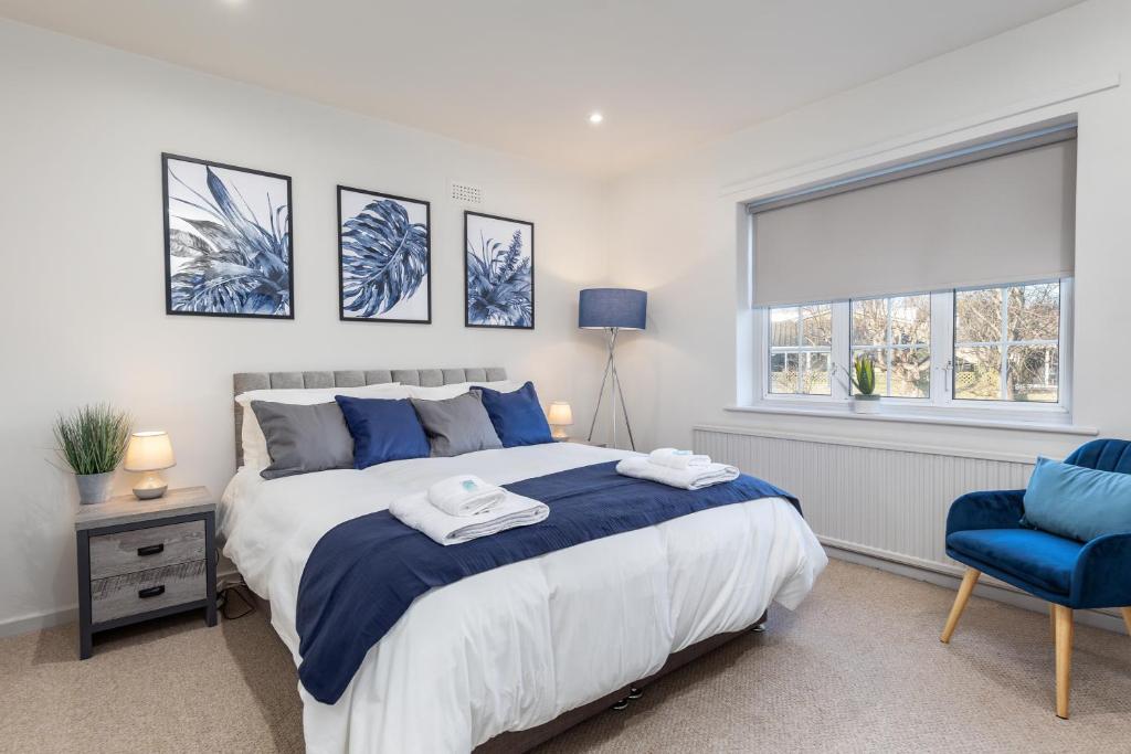 a bedroom with a large bed and a blue chair at Cosy, Exclusive, Sheffield House near Peak District by Ark SA in Sheffield