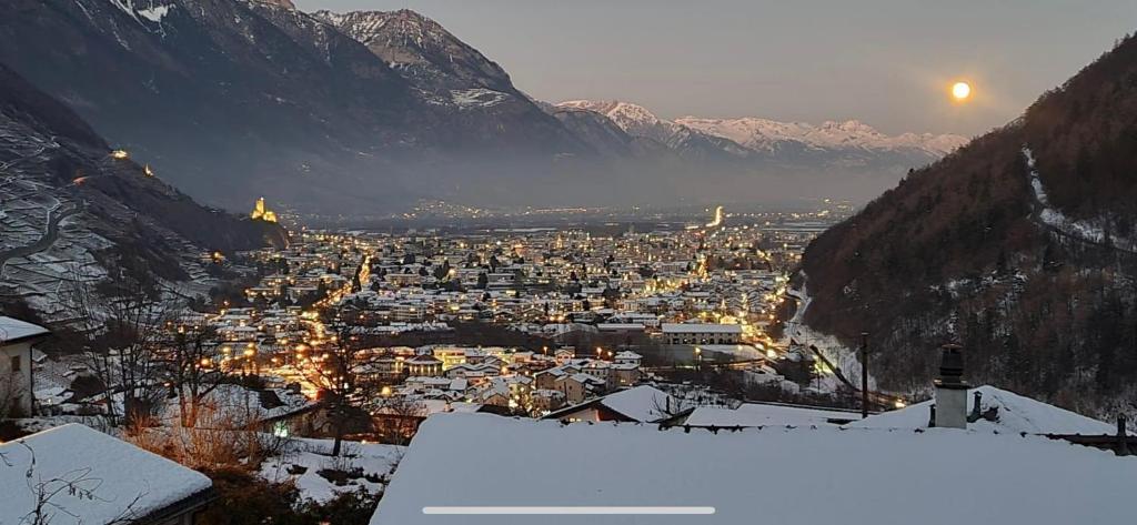 - une vue sur la ville dans la neige et les montagnes dans l'établissement Plein Soleil 2, à Martigny-Ville